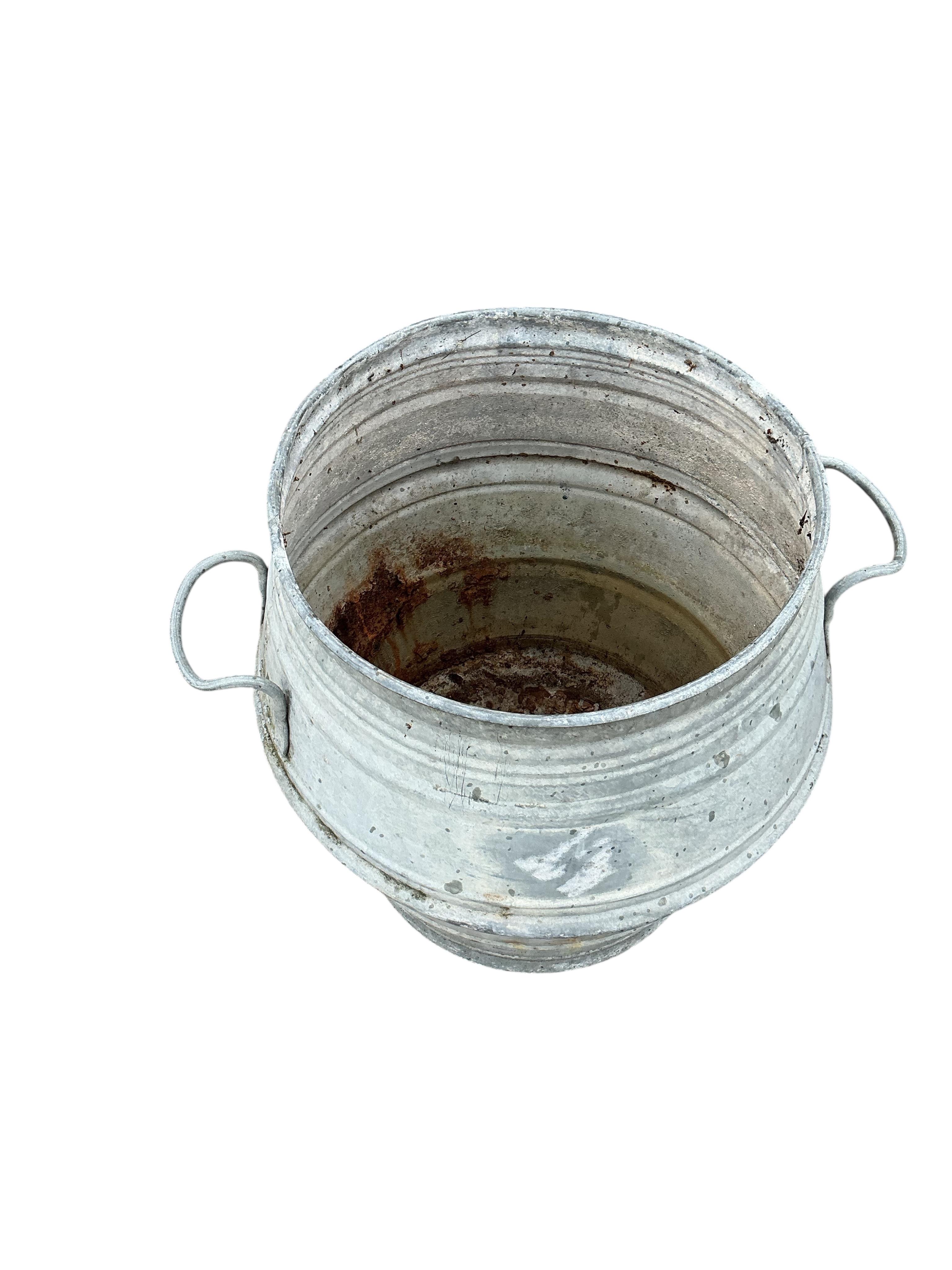A near pair of circular galvanised metal barrels, diameter 46cm, height 52cm